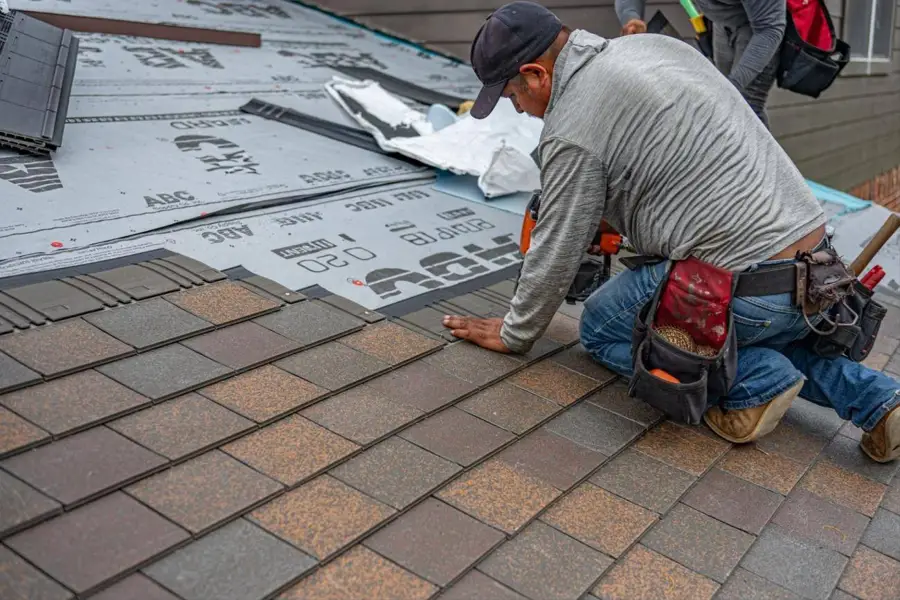 Roofer installing shingles over new underlayment